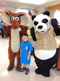 Child in the hospital with people dressed as animals