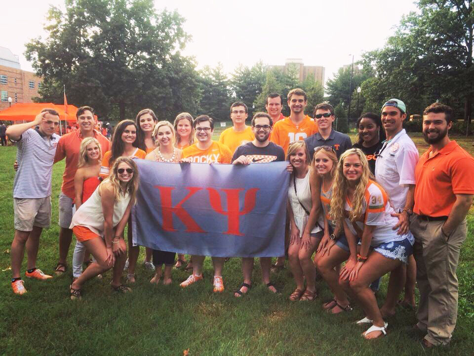 Kappa Psi students with flag of fraternity.