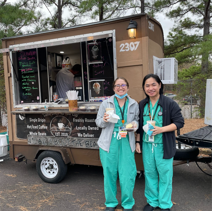 Residents holding coffee and treats outside a food truck