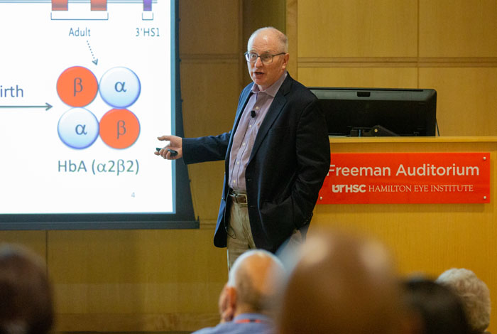 Researcher explaining to a crowd with power point presentation