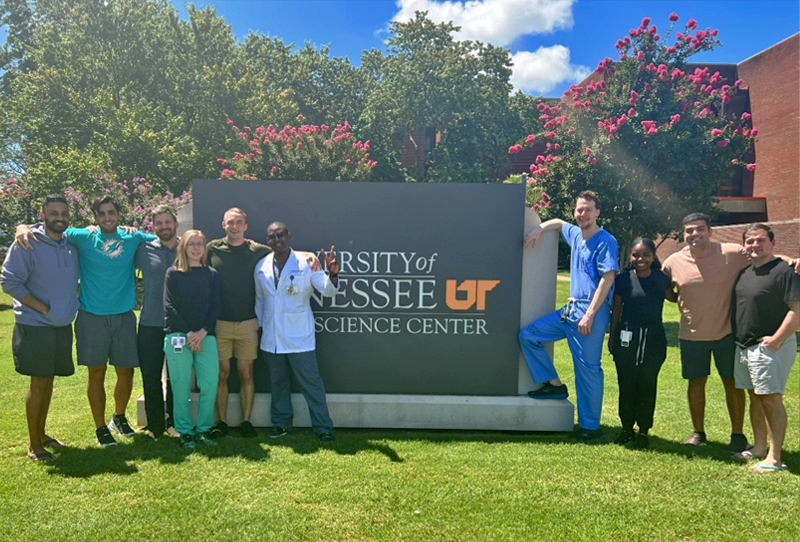 Group of residents in front of the UTHSC sign