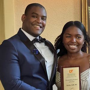 Dr. Cobb holding her outstanding resident of the year award with Dr. Molyneaux