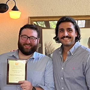 Dr. Fasbinder holding his teaching faculty of the year award with Dr. Garagozlo