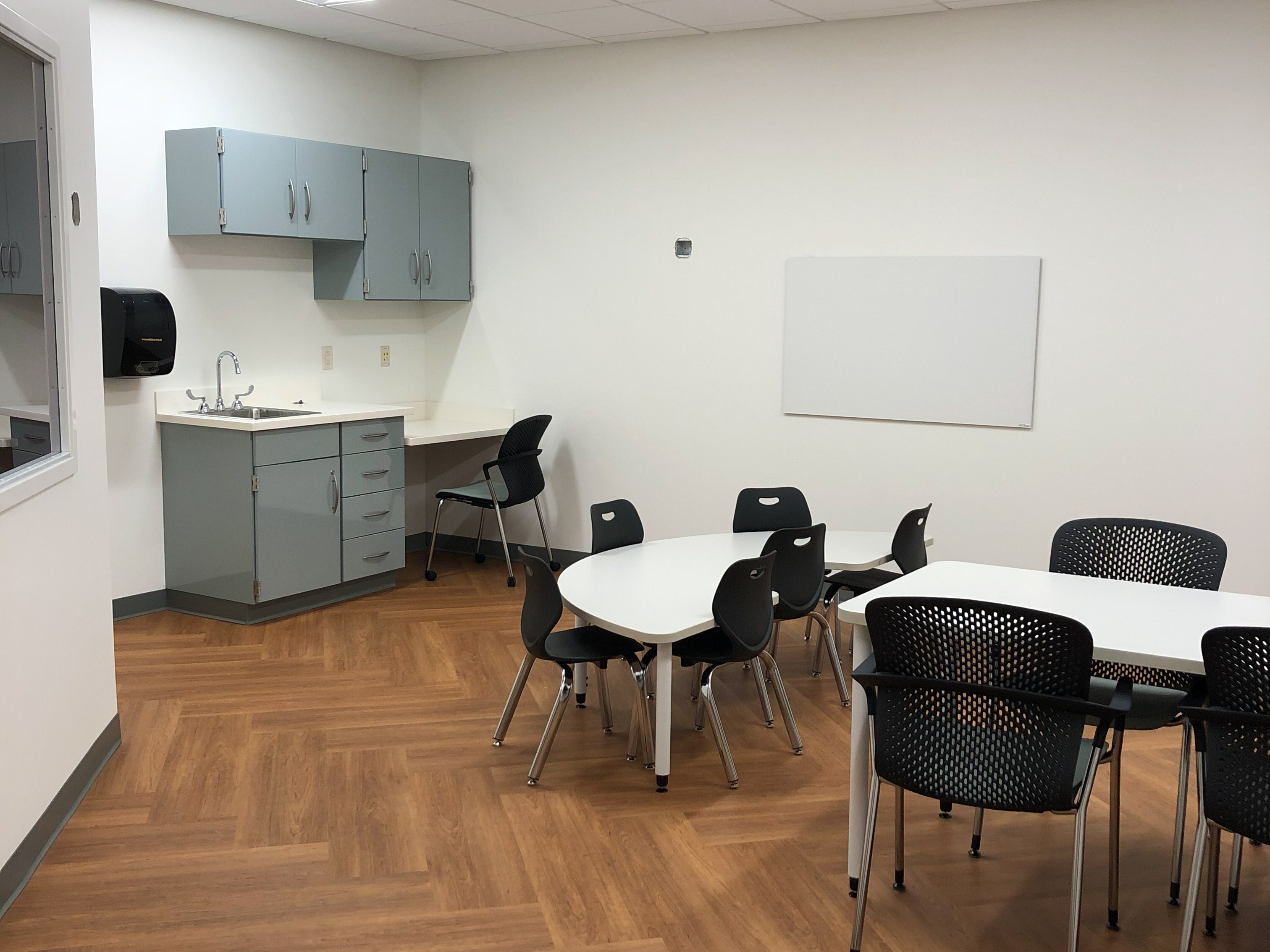 A small group area with tables and chairs at the ASP clinic space.