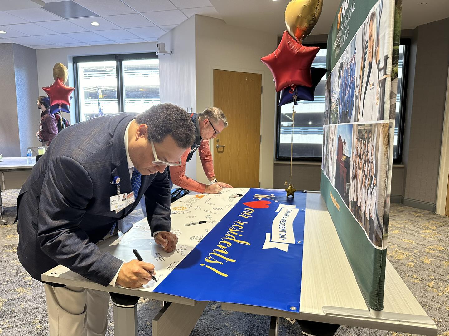 Erlanger Board Member, Lemon Williams, and Surgery Residency Director, Dr. Heath Giles, signing a Thank a Resident Day Banner