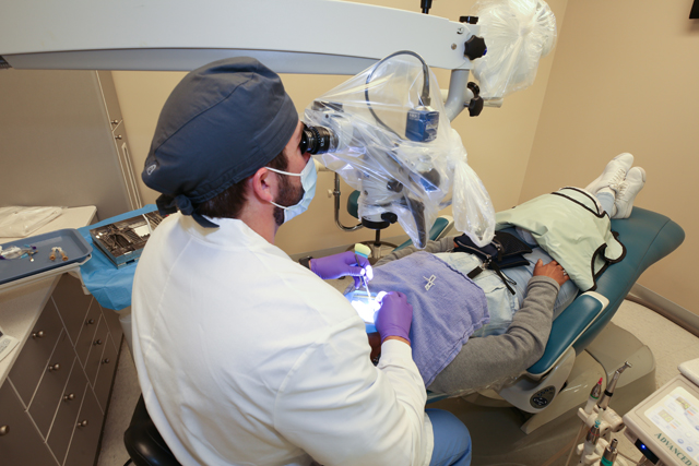 Look over the shoulder of endodontist as he works on a patient in endodontics clinic.