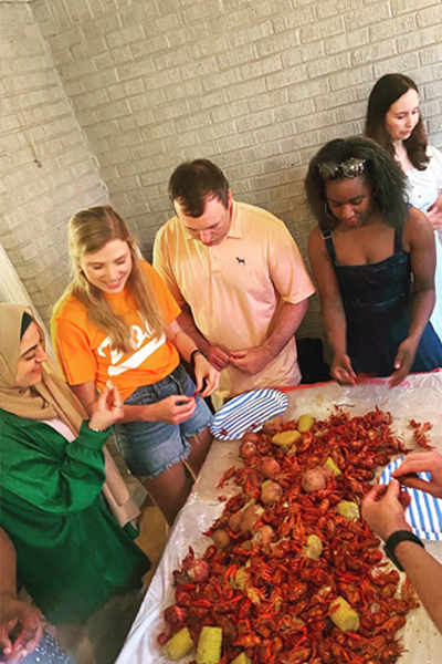 Group of residents standing around a table of a crawfish boil