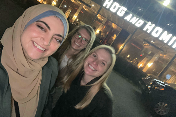 Three female residents outside the Hog & Hominy restaurant