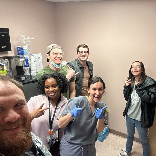 Residents in a hospital room giving a thumb's up