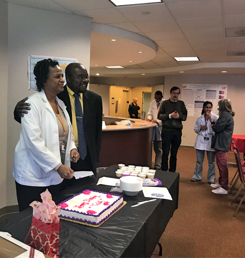 Program coordinator Trish cutting birthday cake with Dr. Dagogo-Jack 