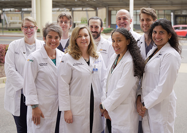 Nine Regional One Health hospitalists posing outside in white coats.