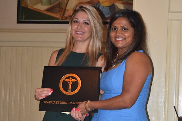 Female fellow receiving certificate from faculty