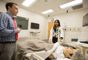 Resident and instructor over a sim dummy