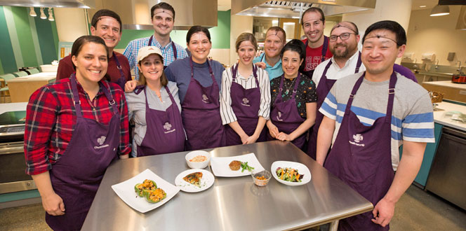 Residents by a table of food in the kitchen