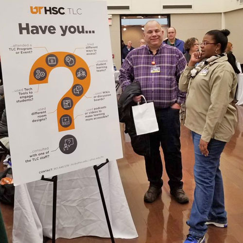 Two participants standing by a vendor sign