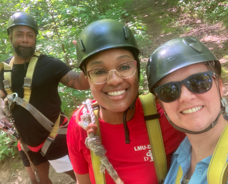 Three residents outside posing before ziplining