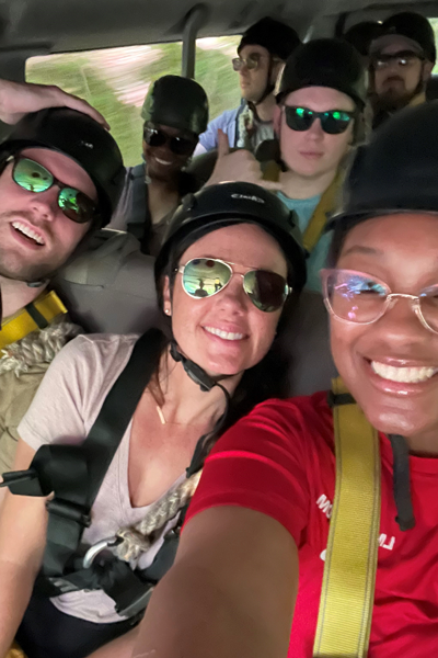 Group of residents wearing helmets in a vehicle