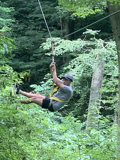 Resident ziplining from a tree outdoors