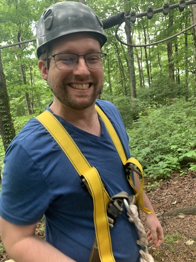 Male resident on the ground before ziplining from a tree outdoors