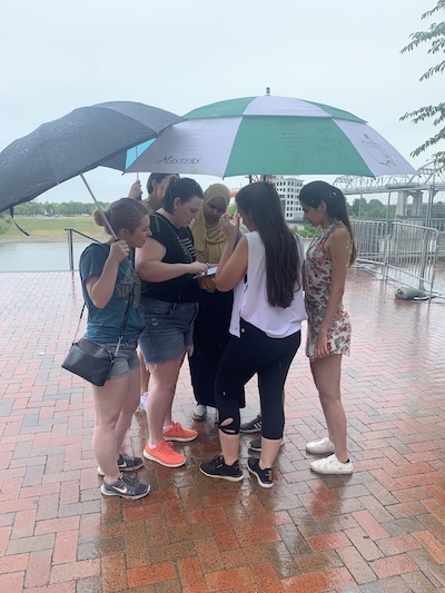 Residents holding umbrellas at the golf range