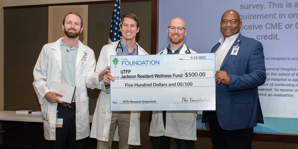 Residents and faculty with a big check