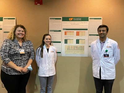 Residents standing before a research presentation