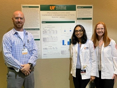 Residents and faculty standing before a research presentation