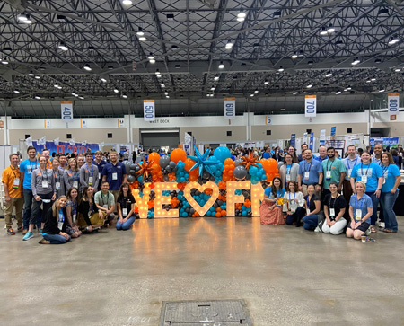 Faculty and residents in front of We heart FM sign and balloons