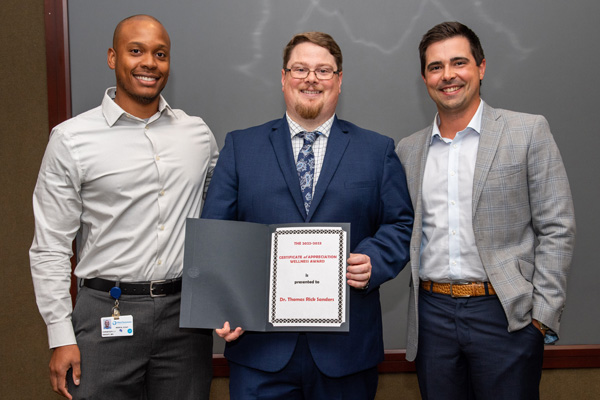 Faculty presenting resident with a certificate