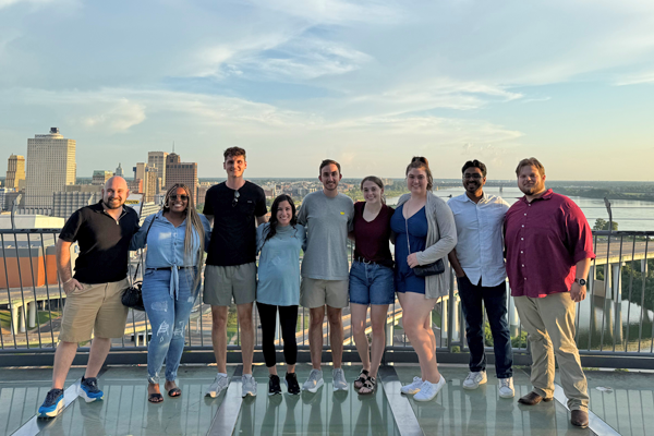 Group photo of incoming residents taken on the balcony of the Bass Pro Pyramid with the city and river in the background