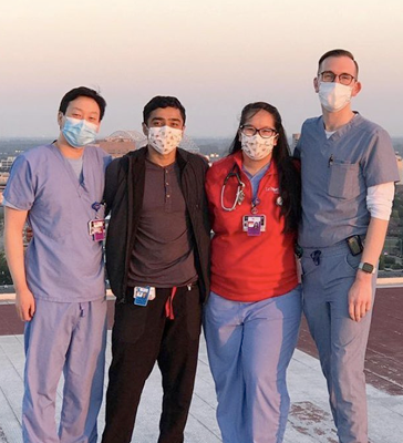 Four residents wearing masks on the rooftop