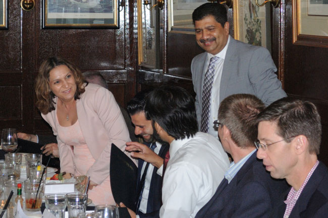 Faculty, staff, and guests talking at the table