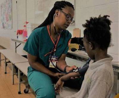 student takes child's blood pressure