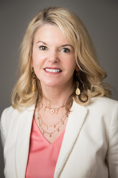 Blonde woman in pink shirt, white jacket