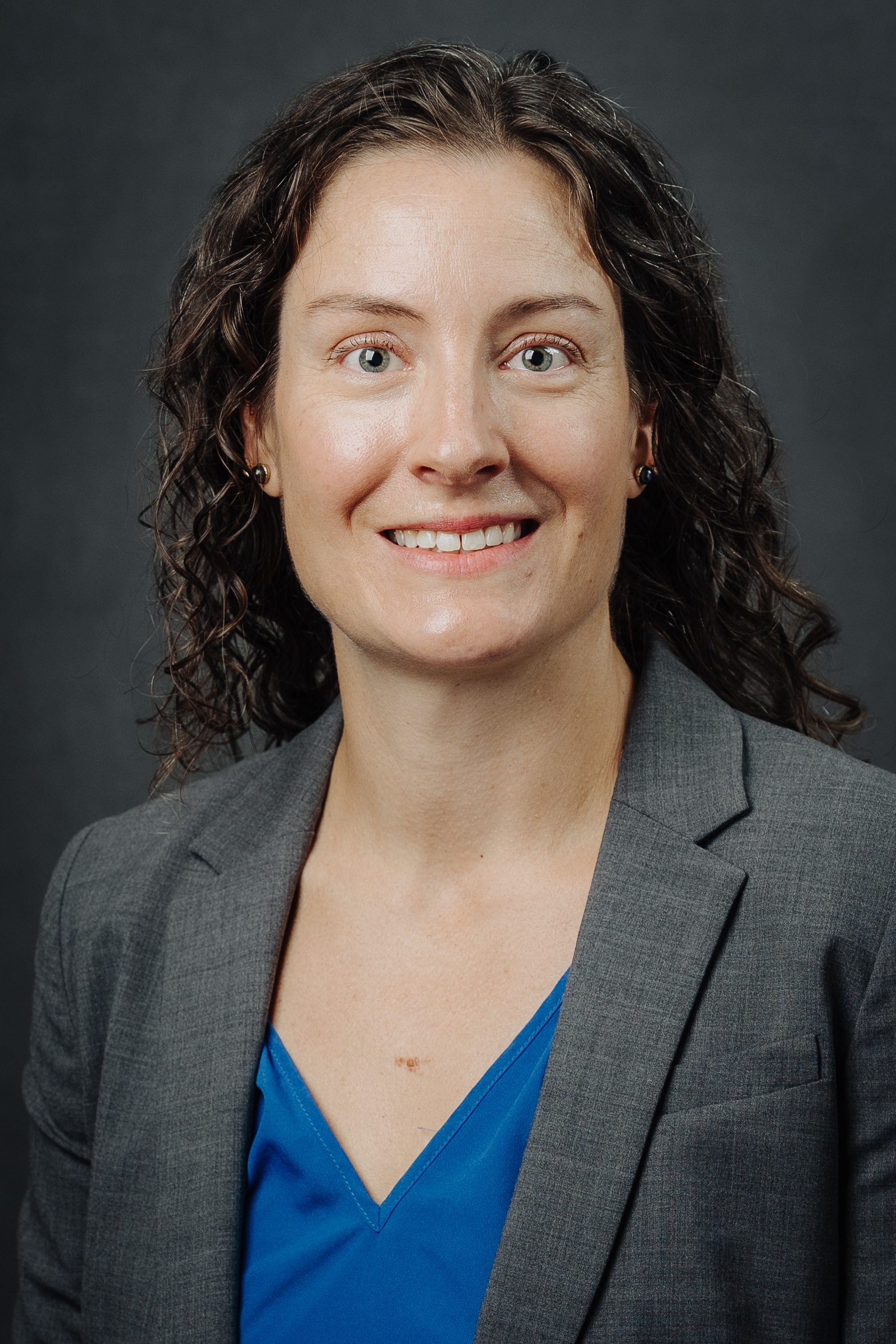 woman in blue shirt and gray jacket