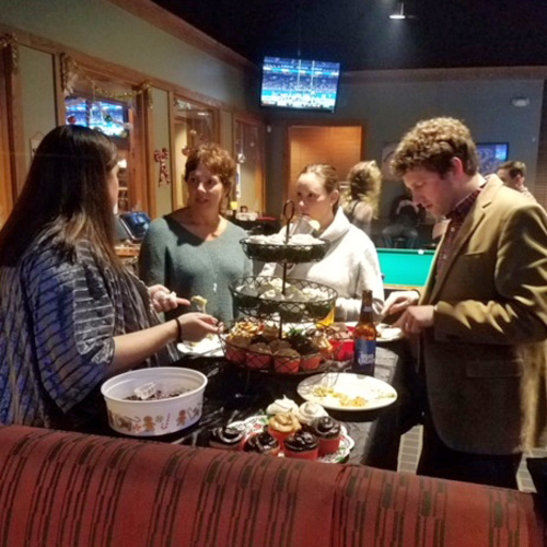 Fellows eating food around a table