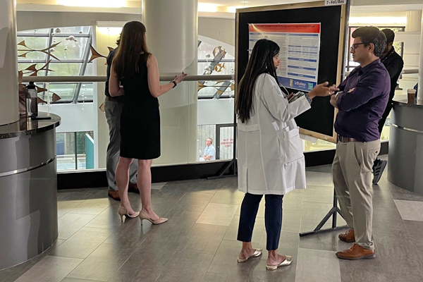 Residents in the hallway in front of a presentation poster