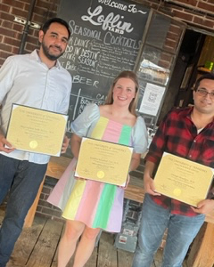 three fellows with graduation certificates