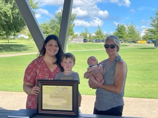 Graduates holding certificates with their children