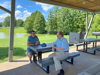 Two men sitting at a bench in a park