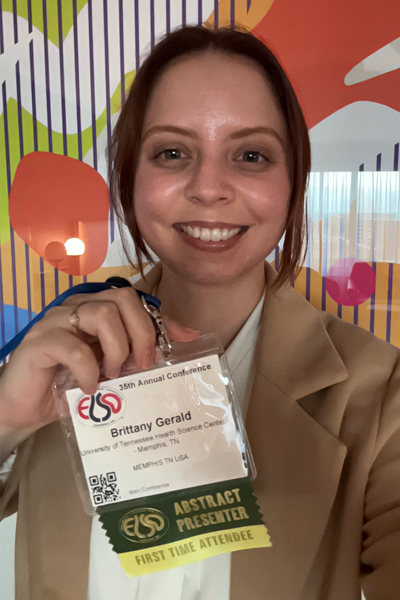 Resident holding her badge at a conference