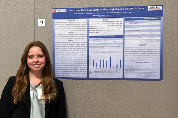Resident standing before a poster presentation