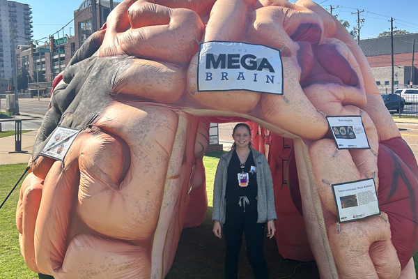 Resident standing in front of a blow up mega brain