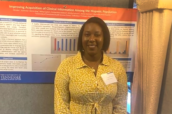 Resident standing before a research poster