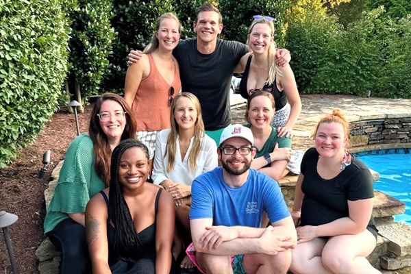 Group of fellows gathered for a photo beside a backyard swimming pool