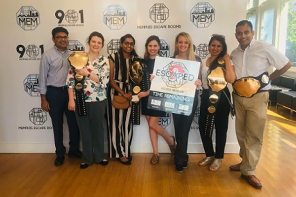 Fellows at an escape room with their belt and certificate