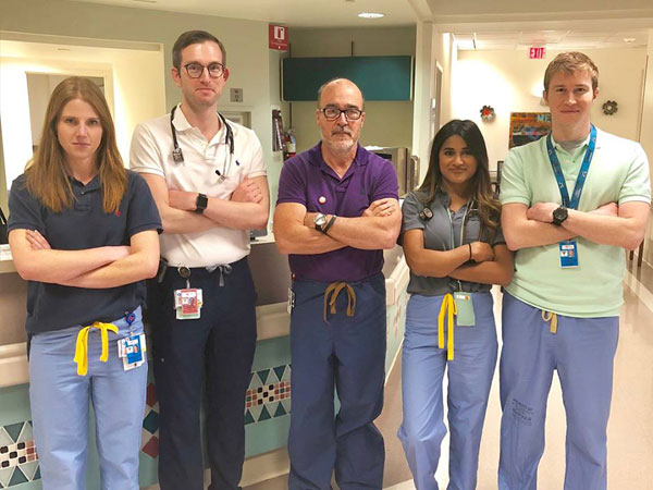 Four residents with Dr. Bugnitz in the hospital hallway