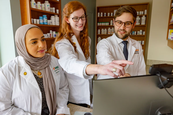 Three pharmacy students at a computer