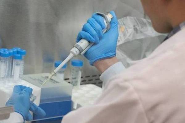 Hand holds lab equipment.