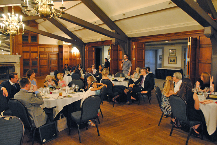 Tables with faculty, fellows, and family at graduation